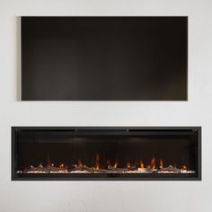 a white wall with a fire place in the middle and a black television above it