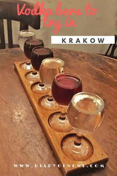 four glasses of wine sitting on top of a wooden tray