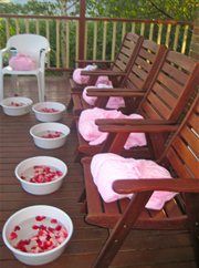 several wooden chairs and bowls with strawberries in them on a deck area that has railings