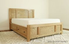 a wooden bed frame with two drawers on each side and a white rug underneath it