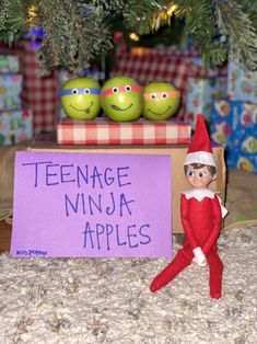 an elf is standing next to a sign that says teenage ninja apples