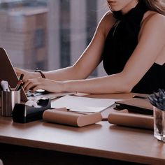 a woman sitting at a desk using a laptop computer