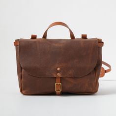 The leather messenger bag is an heirloom-quality bag that's up for any and every kind of work day: Whether you're headed to school, the office, or the field, this bag is ready. The messenger bag is a special-order item made in your choice of Kodiak, Cypress, or Horween leather. Its trim and strap can be made either with your choice of belting-weight leather or in the same leather as the body of the bag. Classic Saddle Bag With Adjustable Strap For Everyday, Timeless Briefcase With Adjustable Strap For Everyday Use, Classic Flap Bag With Leather Handles For Travel, Classic Travel Flap Bag With Leather Handles, Classic Flap Bag With Leather Handles For Everyday, Leather Satchel Flap Bag For On-the-go, Classic Everyday Flap Bag With Leather Handles, Classic Saddle Satchel Bag For Everyday, Classic Everyday Carry Saddle Shoulder Bag