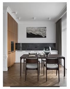 a dining room table with chairs and a painting on the wall