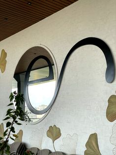 an artisticly designed wall with circular mirrors on it's sides and flowers painted on the walls