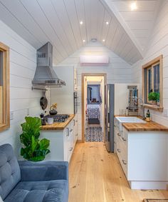 the interior of a tiny home with wood floors, white walls and wooden ceilinging