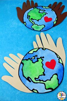 two hands holding the earth with hearts on it