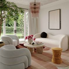 a living room filled with white furniture next to a large glass window covered in pink flowers