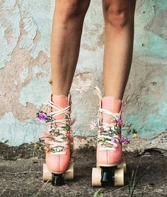 a woman's legs wearing pink roller skates with floral laces on them