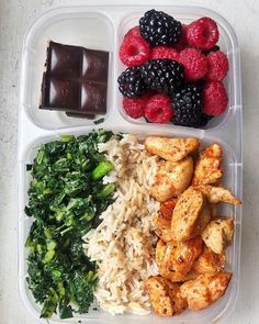 a plastic container filled with rice, fruit and veggies next to chocolate bar