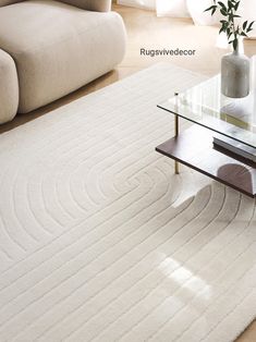 a living room with a white rug and glass table