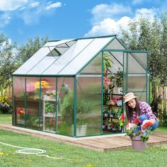 a woman kneeling down in front of a green house