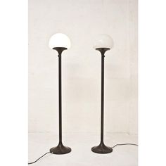 two floor lamps with one light on each side and the other off to the side