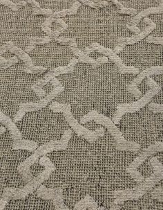 a close up view of an area rug that has been made with grey and white fabric