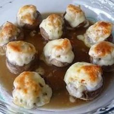 a plate filled with meatballs covered in gravy on top of a table