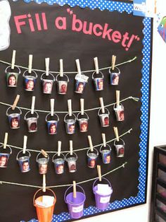 a bulletin board with buckets hanging from it's sides and pictures on them