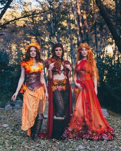 three women dressed in costumes standing next to each other