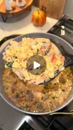 a skillet filled with pasta and vegetables on top of a stove next to an oven