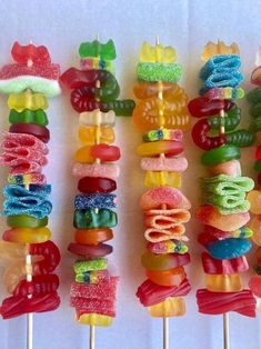 there are many colorful candy lollipops on the skewers with different toppings