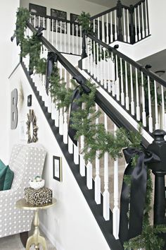 christmas decorations on the banisters and stairs in a house with white railings