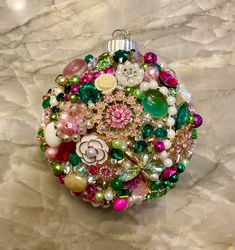 a christmas ornament made out of beads and other assorted items on a marble surface