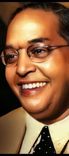 a close up of a person wearing glasses and a suit with a smile on his face