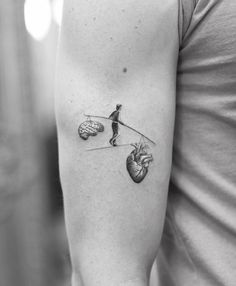 a person with a heart and arrow tattoo on their arm, holding onto a string