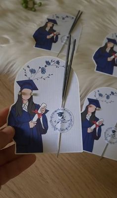 a person holding up some stickers with graduation pictures on them and scissors in their hand