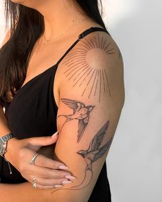 a woman with a humming tattoo on her arm and shoulder is posing for the camera