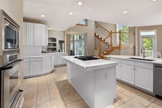 a large kitchen with white cabinets and stainless steel appliances