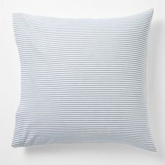 a blue and white striped pillow sitting on top of a bed