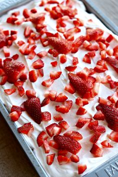 a cake with strawberries on top is sitting on a pan and ready to be baked