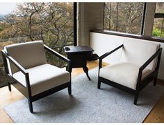 two chairs sitting next to each other on top of a rug in front of a window