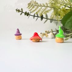 three little gnomes are lined up next to a plant