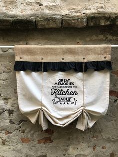 a kitchen table cloth hanging from a clothes line on a stone wall with the words great mogulies are around the kitchen table