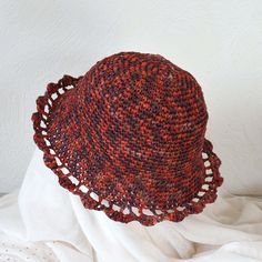 a red and brown hat sitting on top of a white sheet