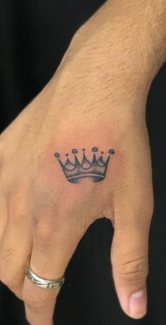 a hand with a crown tattoo on it