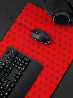 a computer mouse and keyboard sitting on a red carpeted surface with an intricate pattern