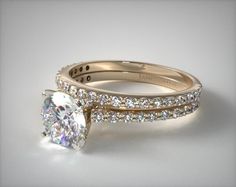 an engagement ring set with a round brilliant cut diamond in the center and side stones on each band