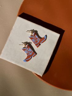 two pairs of red and blue shoes are sitting on top of a white square box