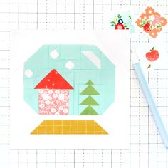 a piece of paper with a house and trees on it next to a pencil, ruler and scissors