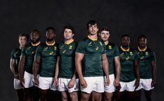 a group of rugby players are posing for a team photo in their green and white uniforms