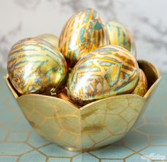 some gold and blue decorated eggs in a bowl