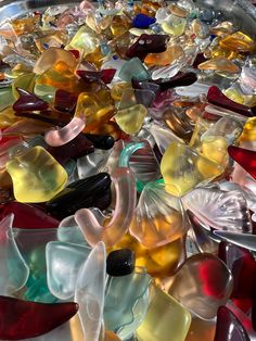 many different colored glass pieces in a metal bowl