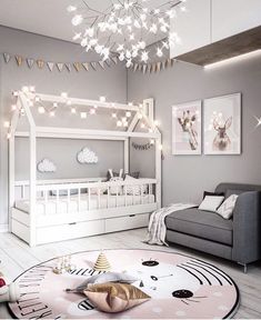 a child's bedroom decorated in grey and white with lights strung from the ceiling