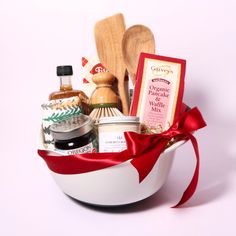 a white bowl filled with lots of food and condiments next to a wooden spoon