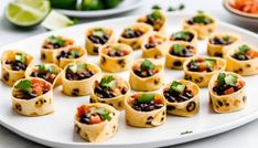 small tortillas filled with black beans and veggies on a white plate