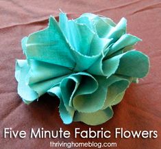 a green flower sitting on top of a brown table cloth with the words five minute fabric flowers