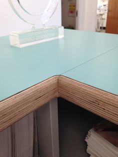 a glass award sitting on top of a wooden desk next to stacks of books and papers