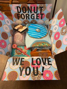 an open cardboard box with donuts and doughnuts on it that says we love you